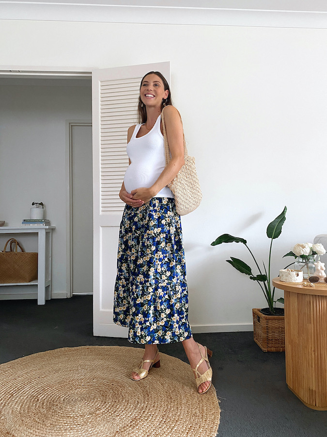 Maternity outfit with midi skirt and white tank top